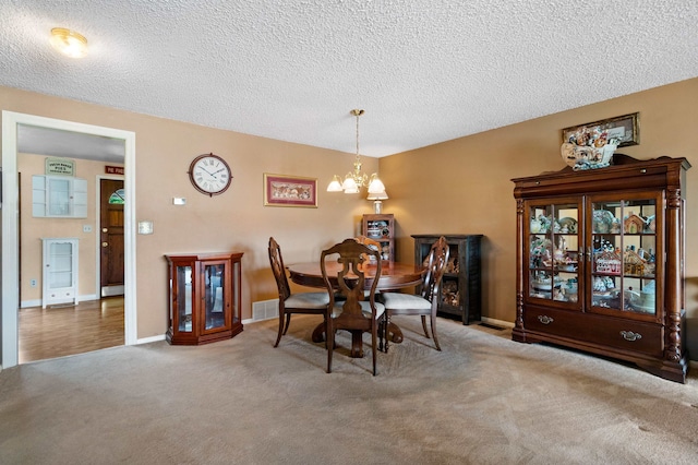 11905 N Atlantic St, Spokane, WA 99218 - dining room featuring a chandelier, carpet, and a textured ceiling