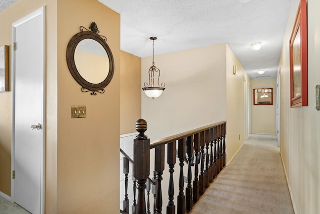 11905 N Atlantic St, Spokane, WA 99218 - hall with light colored carpet, an upstairs landing, and a textured ceiling