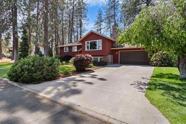 11905 N Atlantic St, Spokane, WA 99218 - split level home featuring an attached garage, driveway, a chimney, and a front yard