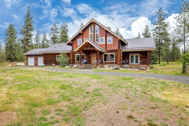 15611 W Pine Bluff Rd, Nine Mile Falls, WA 99026 - cabin featuring log exterior, french doors, covered porch, a metal roof, and a garage