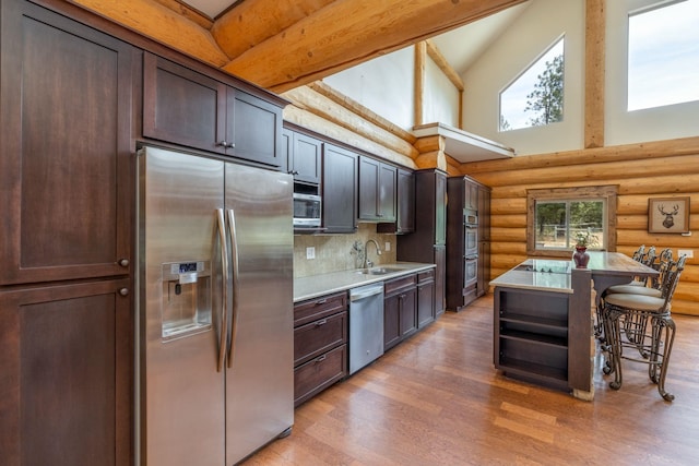 15611 W Pine Bluff Rd, Nine Mile Falls, WA 99026 - kitchen with appliances with stainless steel finishes, rustic walls, high vaulted ceiling, light wood-type flooring, and light countertops