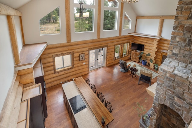 15611 W Pine Bluff Rd, Nine Mile Falls, WA 99026 - living room with rustic walls, a high ceiling, wood finished floors, and a chandelier