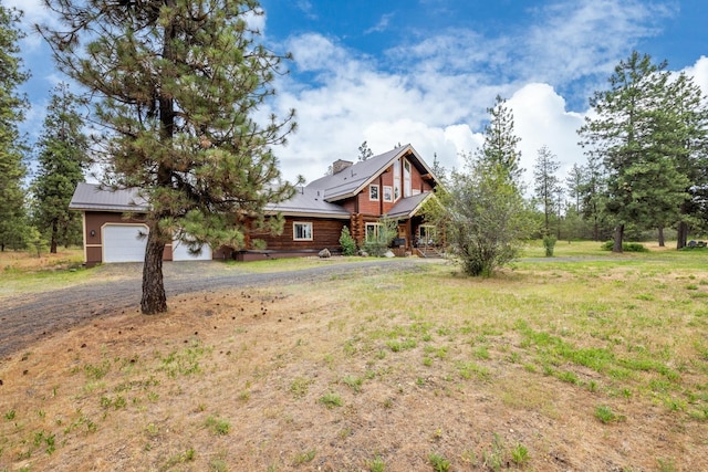 15611 W Pine Bluff Rd, Nine Mile Falls, WA 99026 - log-style house with dirt driveway, log exterior, a metal roof, a front lawn, and covered porch
