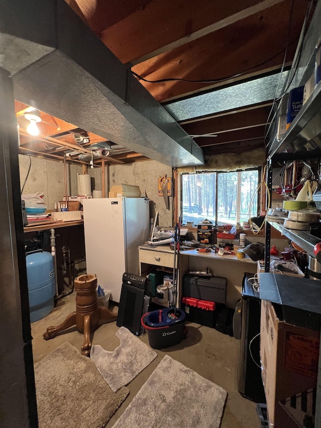 4605 W Pinto Rd, Cheney, WA 99004 - basement featuring a water pressure tank, a workshop area, and freestanding refrigerator