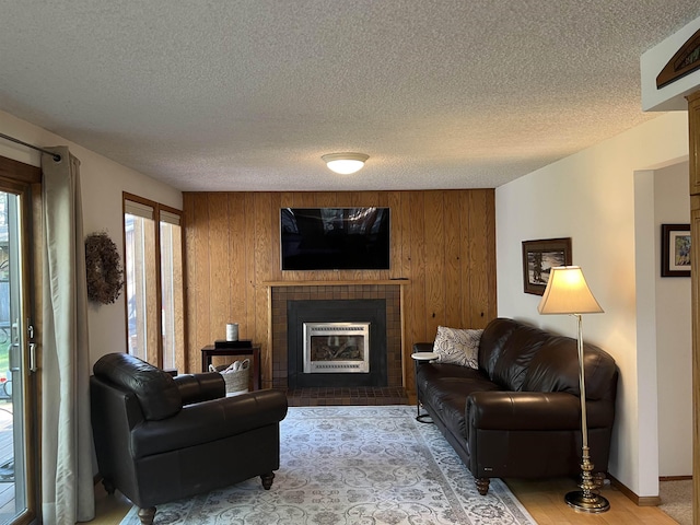 4605 W Pinto Rd, Cheney, WA 99004 - living room with a brick fireplace, a textured ceiling, wooden walls, and wood finished floors