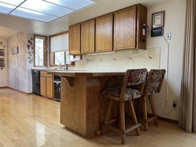 4605 W Pinto Rd, Cheney, WA 99004 - kitchen featuring dishwasher, brown cabinetry, and a kitchen bar