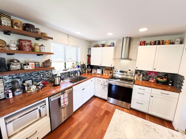 1572 E 20th Hwy, Colville, WA 99114 - kitchen featuring stainless steel appliances, butcher block counters, wall chimney range hood, open shelves, and recessed lighting