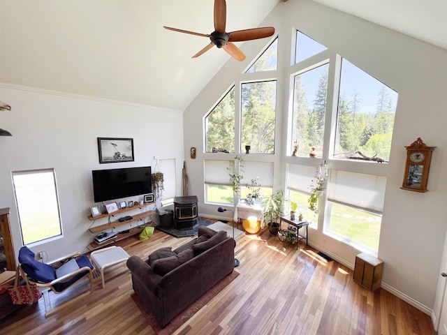 1572 E 20th Hwy, Colville, WA 99114 - living area featuring high vaulted ceiling, a wood stove, ceiling fan, plenty of natural light, and wood finished floors