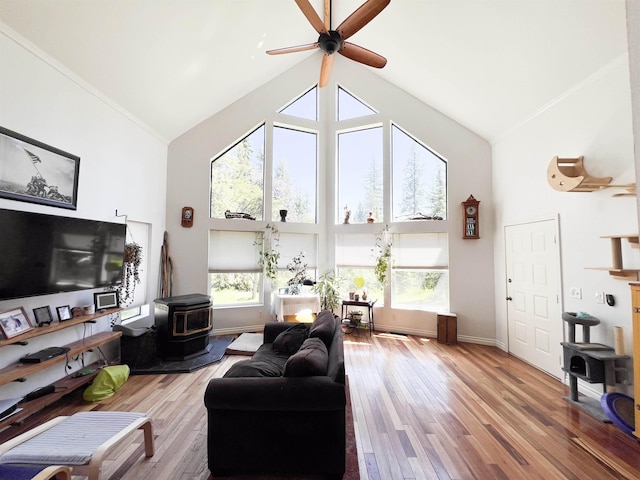 1572 E 20th Hwy, Colville, WA 99114 - living area with high vaulted ceiling, a wood stove, a ceiling fan, and wood finished floors