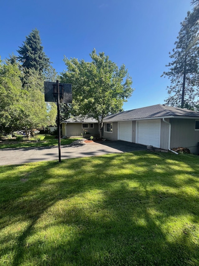 10520 N College Cir, Spokane, WA 99218 - view of front of house featuring a front lawn, an attached garage, and asphalt driveway