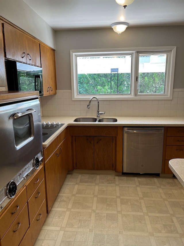 10520 N College Cir, Spokane, WA 99218 - kitchen featuring dishwasher, light flooring, brown cabinets, tasteful backsplash, and light countertops