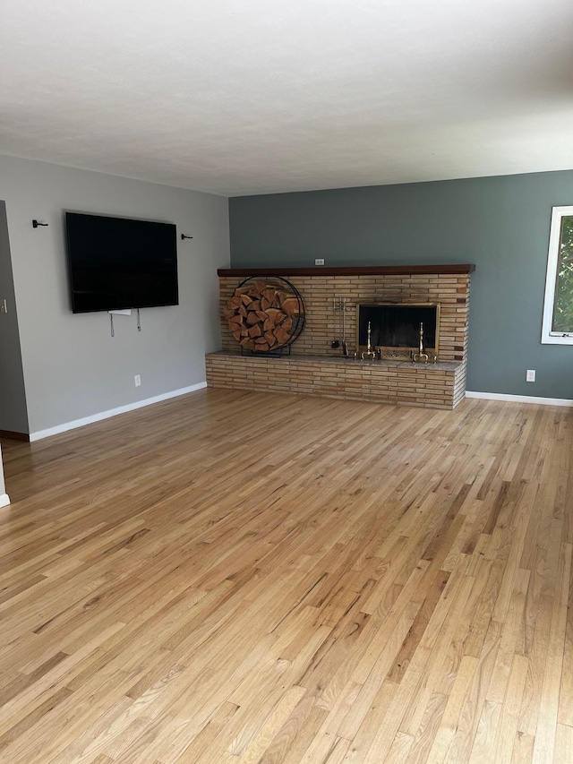10520 N College Cir, Spokane, WA 99218 - unfurnished living room with a brick fireplace and hardwood / wood-style floors