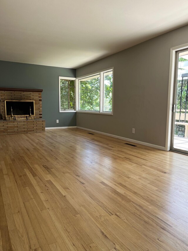 10520 N College Cir, Spokane, WA 99218 - unfurnished living room featuring light wood-style floors and a brick fireplace
