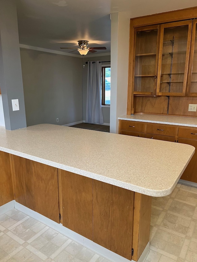 10520 N College Cir, Spokane, WA 99218 - kitchen featuring light flooring, brown cabinetry, ceiling fan, light countertops, and glass insert cabinets