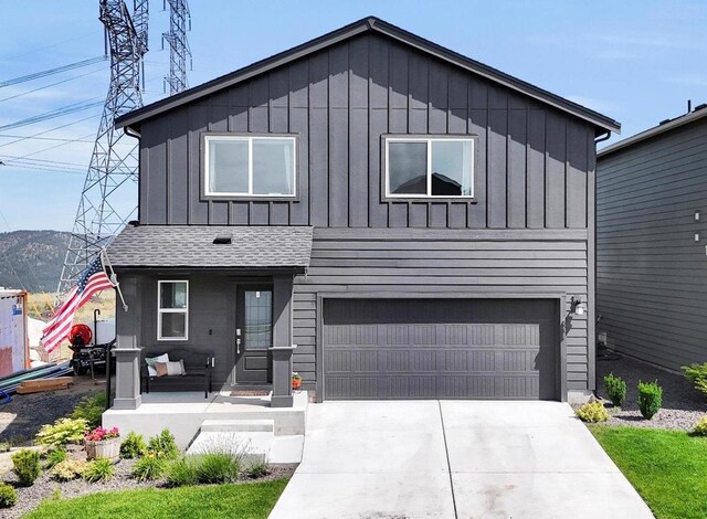 4538 W Brookfield Ave, Spokane, WA 99208 - view of front of house with an attached garage, board and batten siding, covered porch, concrete driveway, and roof with shingles