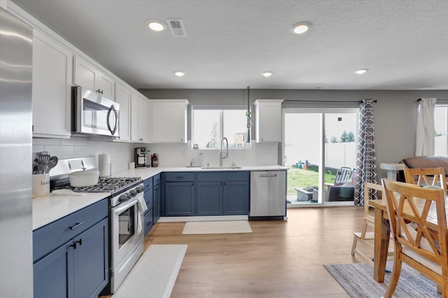 4538 W Brookfield Ave, Spokane, WA 99208 - kitchen featuring appliances with stainless steel finishes, blue cabinets, tasteful backsplash, white cabinets, and recessed lighting
