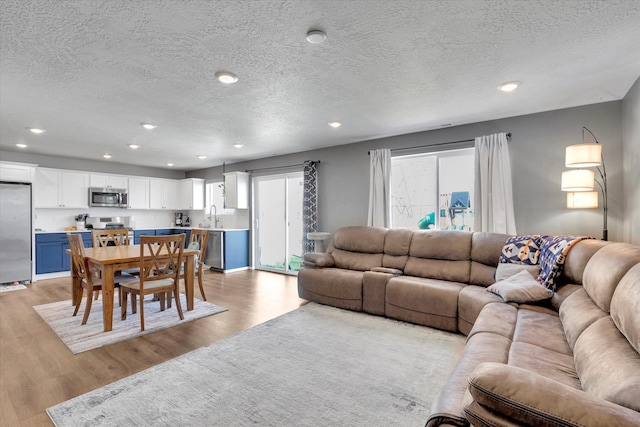 4538 W Brookfield Ave, Spokane, WA 99208 - living room with light wood finished floors, a textured ceiling, plenty of natural light, and recessed lighting