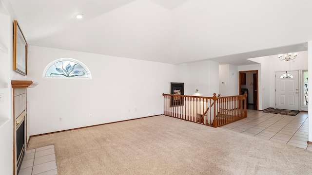 1220 E Brierwood Dr, Spokane, WA 99218 - unfurnished living room with light carpet, a fireplace, a chandelier, and light tile patterned floors