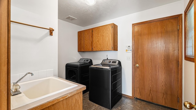 1220 E Brierwood Dr, Spokane, WA 99218 - laundry room with cabinet space, washing machine and dryer, dark stone finish flooring, and a textured ceiling