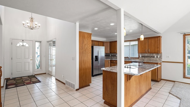 1220 E Brierwood Dr, Spokane, WA 99218 - kitchen featuring stainless steel fridge with ice dispenser, brown cabinets, backsplash, light tile patterned floors, and recessed lighting