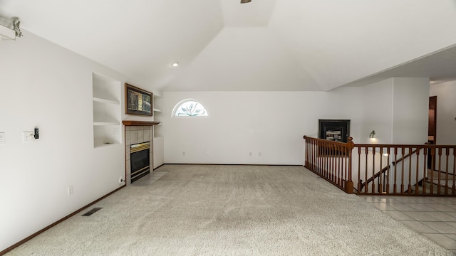 1220 E Brierwood Dr, Spokane, WA 99218 - unfurnished living room featuring a tiled fireplace, vaulted ceiling, and light colored carpet