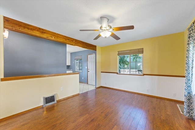 4303 W Crown Ave, Spokane, WA 99205 - unfurnished living room featuring ceiling fan, wood finished floors, beamed ceiling, and wainscoting