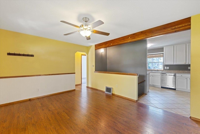 4303 W Crown Ave, Spokane, WA 99205 - unfurnished living room featuring light wood-style floors, a ceiling fan, and arched walkways