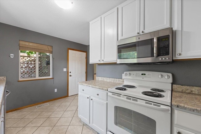 4303 W Crown Ave, Spokane, WA 99205 - kitchen with white electric range oven, stainless steel microwave, white cabinetry, and a textured ceiling