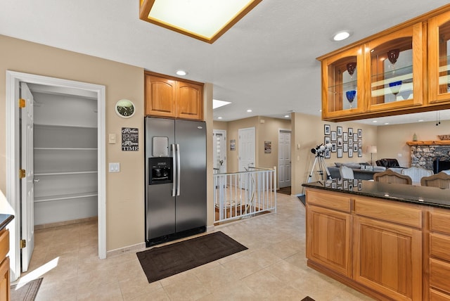 161 S Alaska Ln, Cusick, WA 99119 - kitchen featuring stainless steel refrigerator with ice dispenser, dark countertops, glass insert cabinets, recessed lighting, and light tile patterned flooring