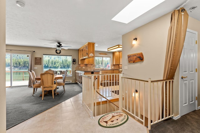 161 S Alaska Ln, Cusick, WA 99119 - tiled living area featuring carpet flooring, a skylight, and ceiling fan
