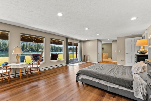 161 S Alaska Ln, Cusick, WA 99119 - bedroom featuring a textured ceiling, recessed lighting, wood finished floors, multiple windows, and access to outside