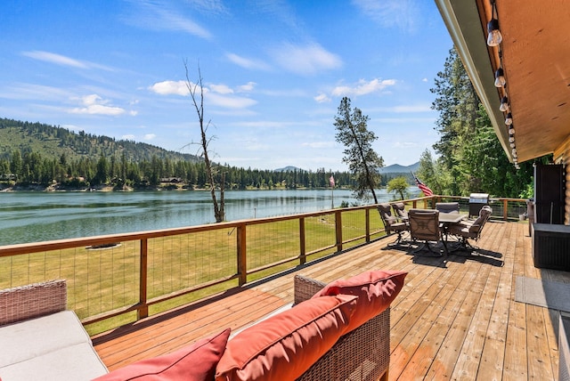 161 S Alaska Ln, Cusick, WA 99119 - deck featuring a water view, outdoor dining space, a lawn, and a forest view
