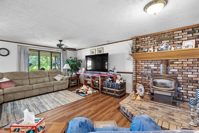 4821 S Conklin Rd, Greenacres, WA 99016 - living area with a textured ceiling, a ceiling fan, crown molding, a wood stove, and wood finished floors