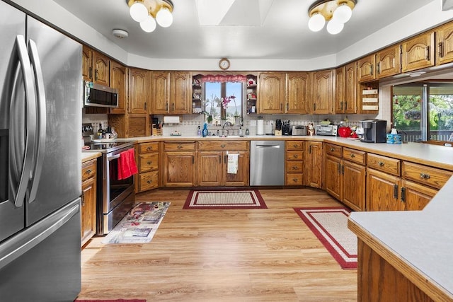 4821 S Conklin Rd, Greenacres, WA 99016 - kitchen with stainless steel appliances, brown cabinets, a skylight, and plenty of natural light