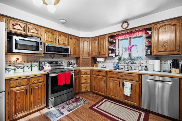 4821 S Conklin Rd, Greenacres, WA 99016 - kitchen with stainless steel appliances, open shelves, backsplash, and brown cabinetry