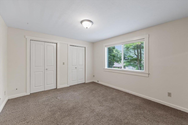 1007 W 15th Ave, Spokane, WA 99203 - unfurnished bedroom with multiple closets and carpet flooring