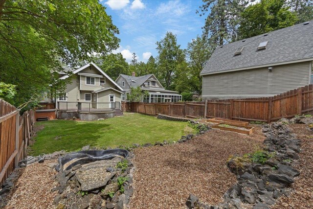 1007 W 15th Ave, Spokane, WA 99203 - fenced backyard with a deck and a vegetable garden