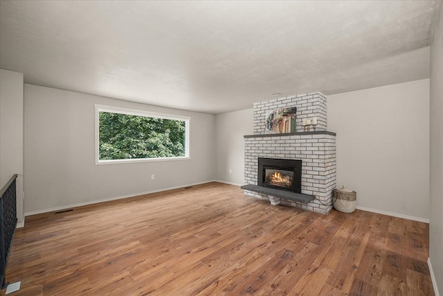 426 E 17th St, Spokane, WA 99203 - unfurnished living room with a brick fireplace and wood finished floors