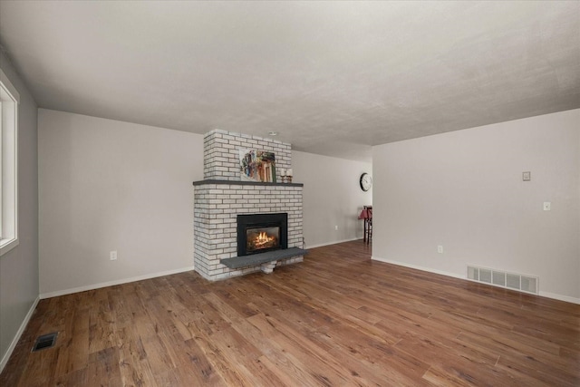 426 E 17th St, Spokane, WA 99203 - unfurnished living room featuring wood finished floors and a brick fireplace