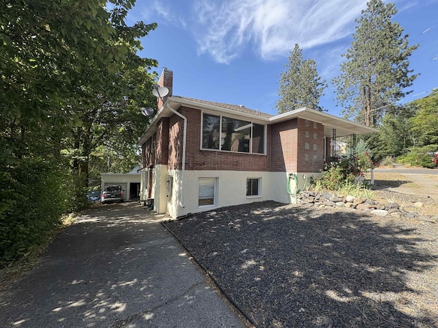 820/828 W 11th Ave, Spokane, WA 99204 - view of home's exterior featuring brick siding, a chimney, and driveway