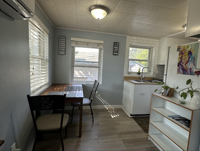 820/828 W 11th Ave, Spokane, WA 99204 - kitchen featuring crown molding, white cabinetry, dark wood finished floors, and a wall unit AC