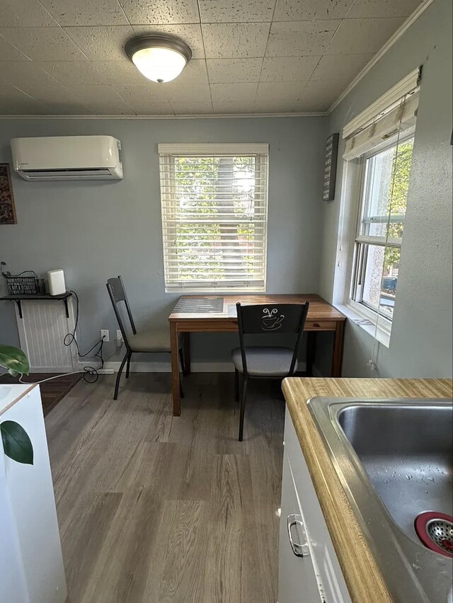 820/828 W 11th Ave, Spokane, WA 99204 - dining room featuring a wall unit AC, wood finished floors, and crown molding