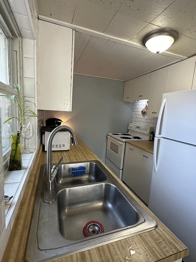 820/828 W 11th Ave, Spokane, WA 99204 - kitchen with white appliances, backsplash, white cabinets, and plenty of natural light