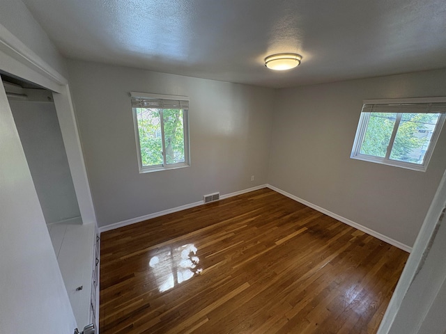 820/828 W 11th Ave, Spokane, WA 99204 - unfurnished bedroom with multiple windows, dark wood-type flooring, and a closet