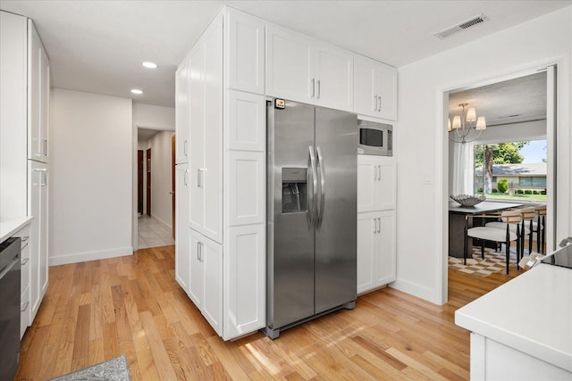 915 W 32nd Ave, Spokane, WA 99203 - kitchen with appliances with stainless steel finishes, light wood-style flooring, white cabinetry, a chandelier, and recessed lighting