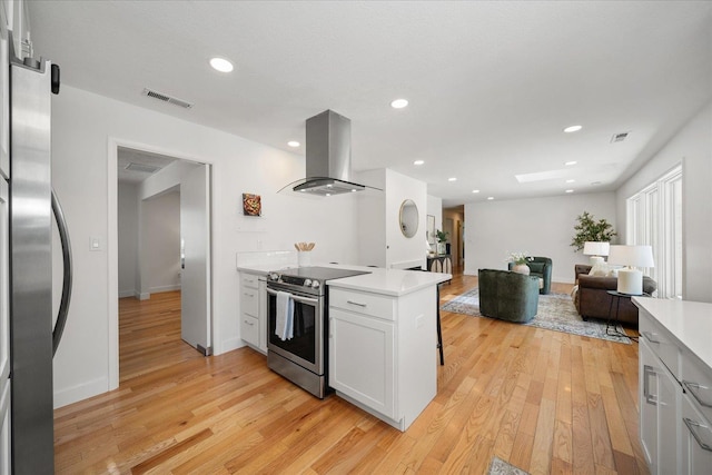 915 W 32nd Ave, Spokane, WA 99203 - kitchen with stainless steel appliances, island range hood, light wood-style floors, light countertops, and recessed lighting
