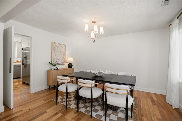 915 W 32nd Ave, Spokane, WA 99203 - dining space featuring light wood-type flooring, a chandelier, and a textured ceiling