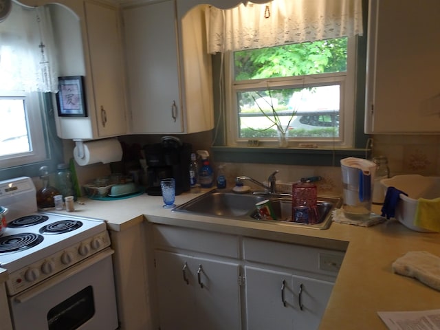 210 W Bartlett St, Oakesdale, WA 99158 - kitchen with white range with electric stovetop, light countertops, and white cabinetry