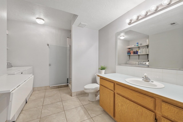 15618 N Chronicle Ct, Mead, WA 99021 - full bathroom featuring separate washer and dryer, vanity, a stall shower, a textured ceiling, and tile patterned flooring