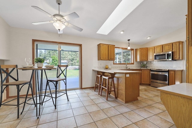 15618 N Chronicle Ct, Mead, WA 99021 - kitchen featuring appliances with stainless steel finishes, tasteful backsplash, a peninsula, light countertops, and lofted ceiling